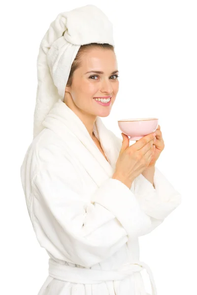 Молодая женщина в халате показывает чашку — стоковое фото