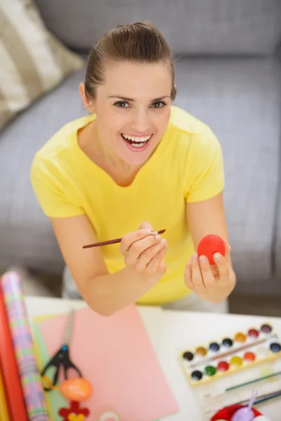 Sorrindo jovem mulher mostrando ovo vermelho de Páscoa — Fotografia de Stock