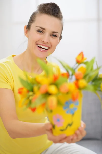 Glückliche junge Frau zeigt Strauß Tulpen im Eimer — Stockfoto