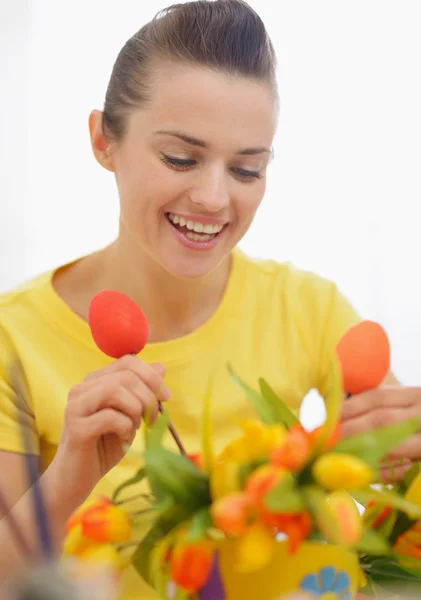 Feliz joven mujer haciendo decoración de Pascua con tulipanes y huevos —  Fotos de Stock