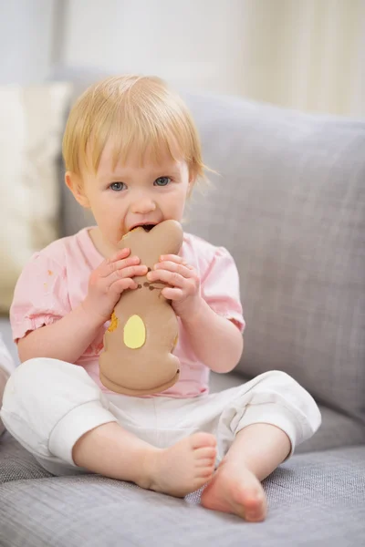 Baby eating Easter rabbit shaped cookie — Stock Photo, Image