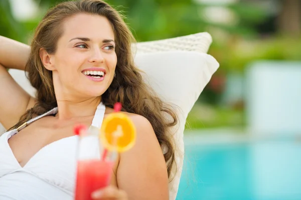 Mujer joven relajándose en la piscina con cóctel — Foto de Stock