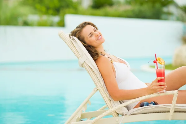 Mujer joven relajándose en la piscina con cóctel — Foto de Stock