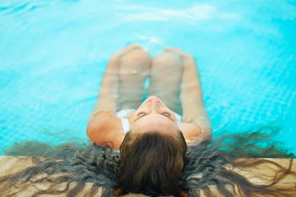 Giovane donna rilassante in piscina — Foto Stock