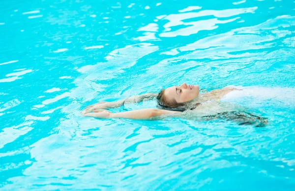 Jeune femme nageant dans la piscine — Photo