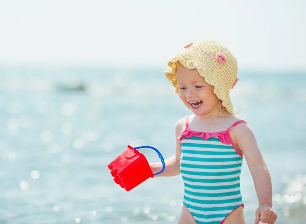 Baby playing with pail near sea — Stock Photo, Image