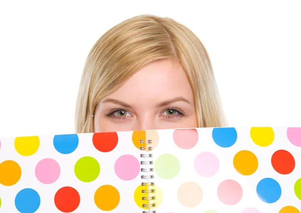 Closeup on student girl hiding behind notebook — Stock Photo, Image