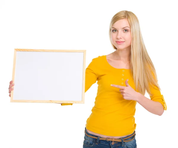 Happy student girl pointing on blank board — Stock Photo, Image