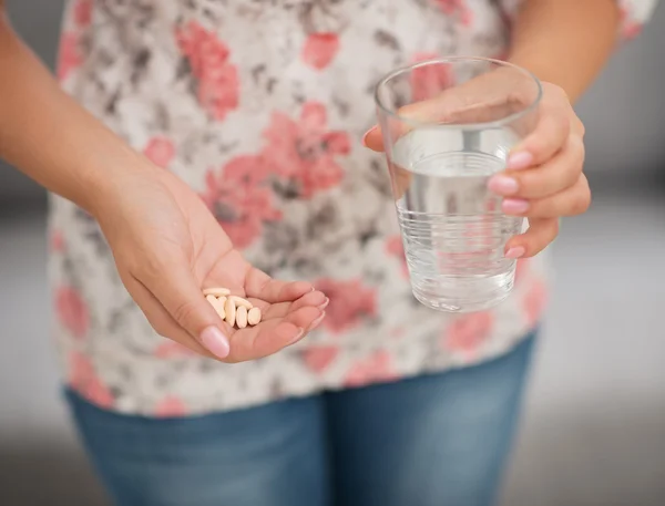 Primer plano de la píldora y vaso de agua en la mano de la mujer — Foto de Stock