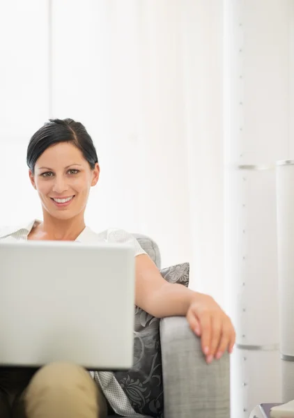 Lachende jonge vrouw met behulp van laptop — Stockfoto