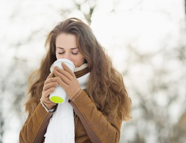 Jeune femme boire une boisson chaude dans le parc d'hiver — Photo