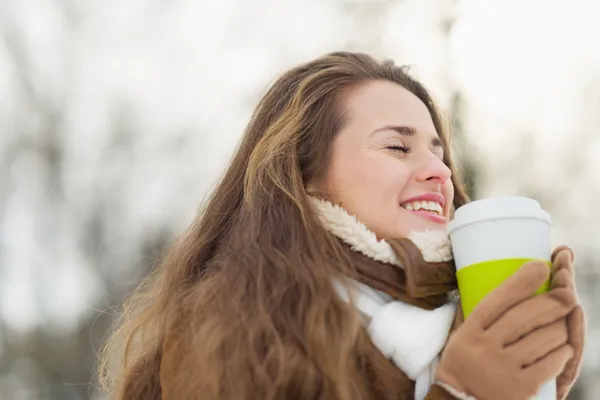 Happy young woman enjoying hot beverage in winter park — Stock Photo, Image