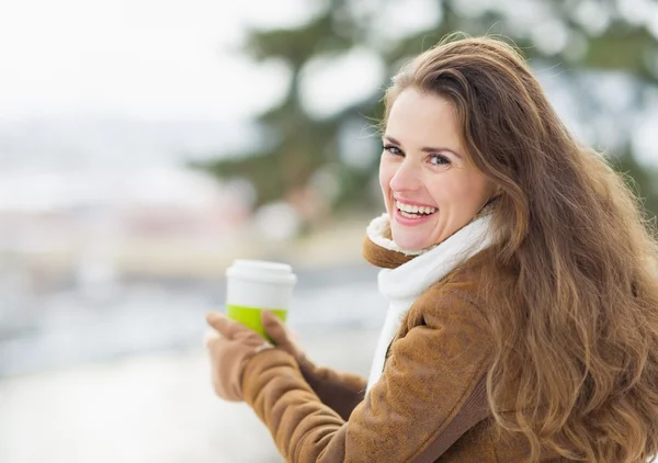 Portret van gelukkige jonge vrouw met warme drank — Stockfoto