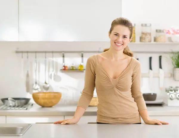 Modern mutfakta gülümseyen genç ev kadınının portresi. — Stok fotoğraf