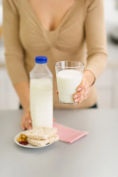 Closeup on young woman holding out glass of milk — Stock Photo, Image