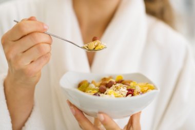 Closeup on woman in bathrobe eating healthy breakfast