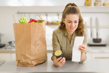 gülümseyen genç ev hanımı alımları ve onay shopp sonra inceliyor.