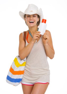 Genç plaj güneş ekran Creme holding şapkalı gülümseyen