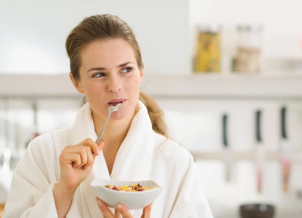 Gelukkig jonge vrouw in badjas eten gezond ontbijt — Stockfoto