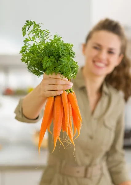 Closeup on fresh carrots in hand of woman — Stock Photo, Image