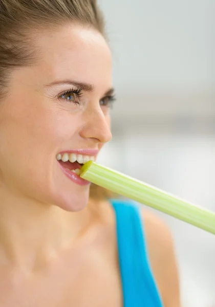 Closeup on young woman biting celery — Stock Photo, Image