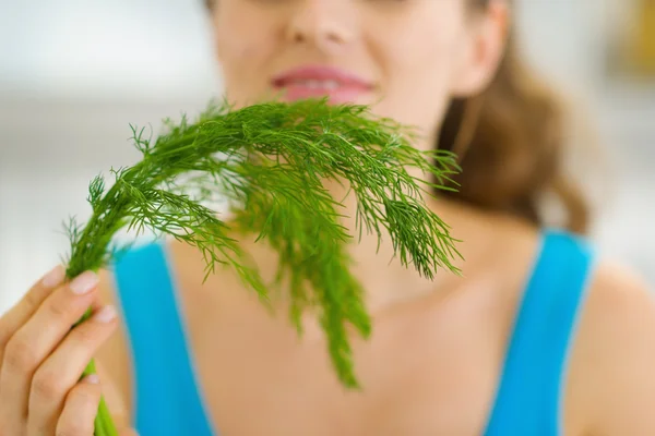 Closeup on young woman smelling fresh dill — Stock Photo, Image