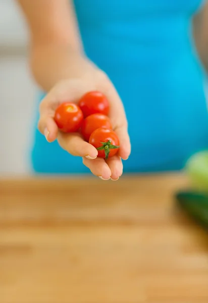 Närbild på körsbär tomat i hand ung kvinna — Stockfoto