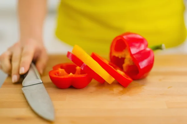 Primo piano su peperone rosso con fetta gialla sul tagliere — Foto Stock