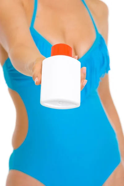 Primer plano en crema protector solar en la mano de la mujer joven en traje de baño —  Fotos de Stock