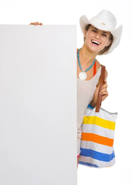 Souriant jeune femme de plage en chapeau montrant panneau d'affichage vierge — Photo