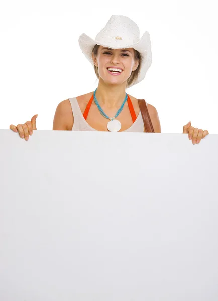 Felice giovane donna spiaggia in cappello che mostra cartellone bianco — Foto Stock