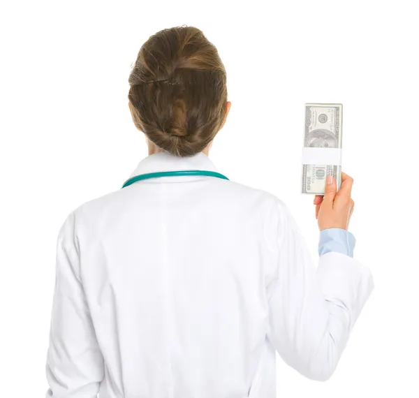Medical doctor woman holding pack of dollars . rear view — Stock Photo, Image