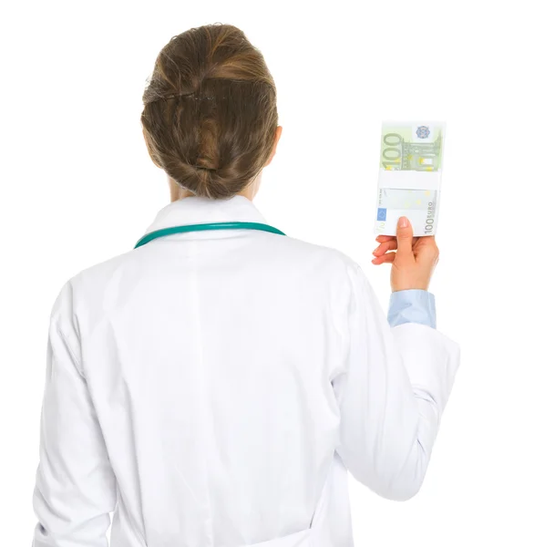 Γυναίκα ιατρός κρατώντας πακέτο ευρώ. πίσω όψη — Φωτογραφία Αρχείου