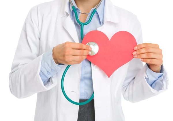 Closeup on medical doctor woman listening paper heart — Stock Photo, Image