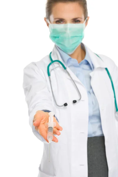 Medico donna in maschera mostrando siringa — Foto Stock