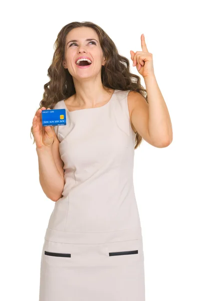 Happy young woman with credit card pointing on copy space — Stock Photo, Image