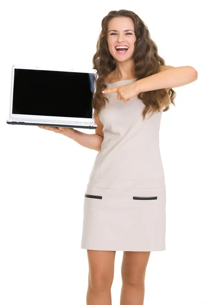 Retrato de mujer joven sonriente señalando en el ordenador portátil con sc en blanco —  Fotos de Stock