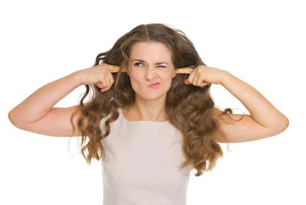 Напряженная молодая женщина закрывает уши — стоковое фото