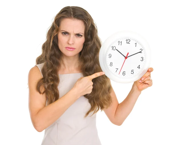 Préoccupé jeune femme pointant sur horloge — Photo