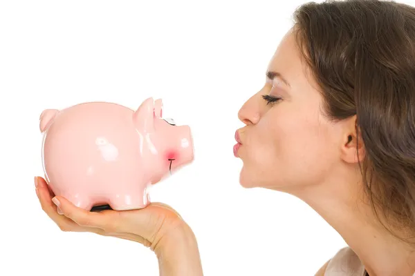 Close-up no jovem mulher beijos porquinho banco — Fotografia de Stock
