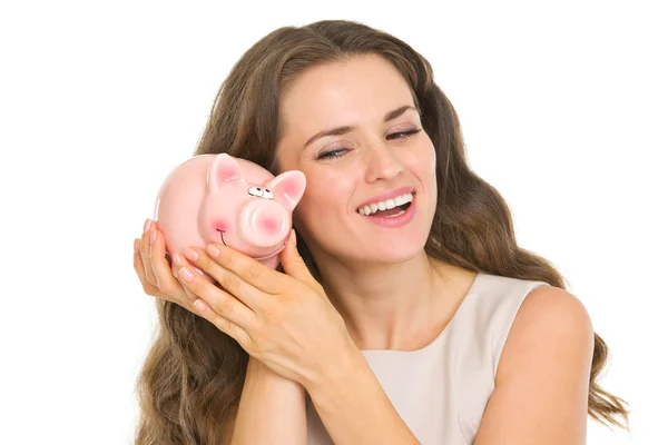 Happy young woman shaking piggy bank — Stock Photo, Image