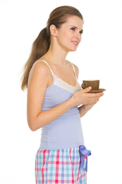 Jonge vrouw in pyjama met kop koffie — Stockfoto