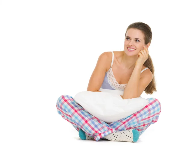 Happy young woman in pajamas sitting with pillow — Stock Photo, Image