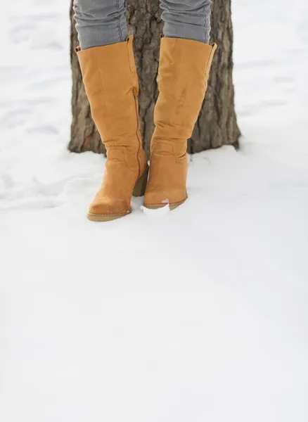 Gros plan sur les jambes des femmes en bottes d'hiver sur la neige — Photo