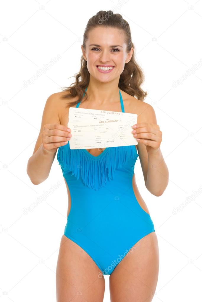 Happy young woman in swimsuit showing air tickets