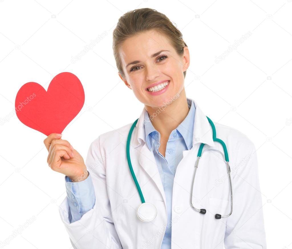 Smiling medical doctor woman holding paper heart