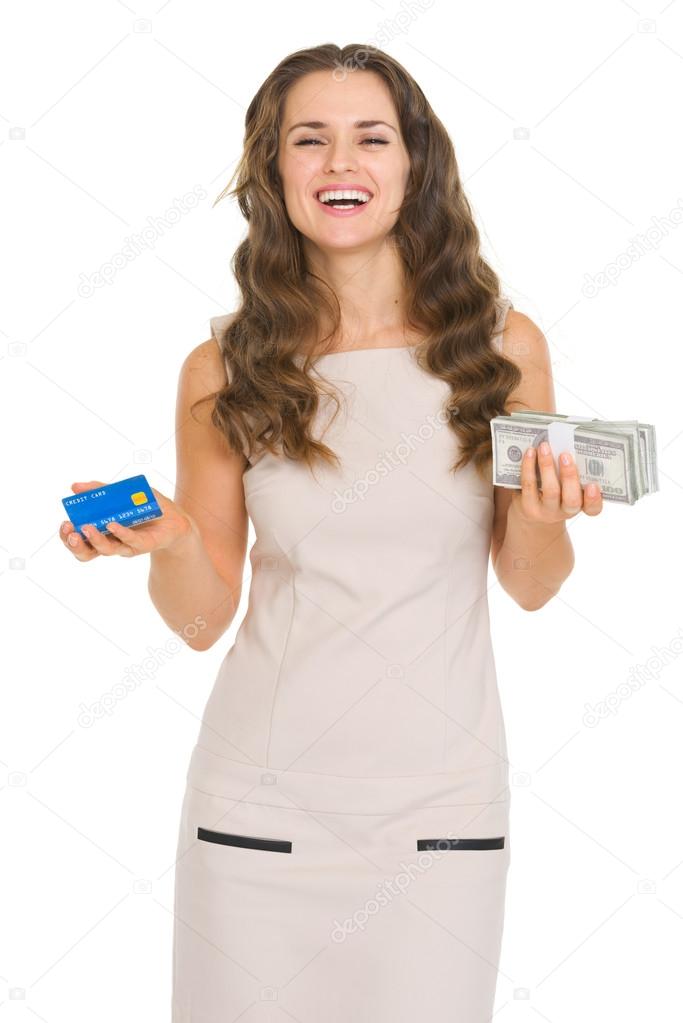 Happy young woman holding credit card and money packs