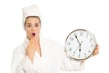 Surprised young woman in bathrobe with clock clipart
