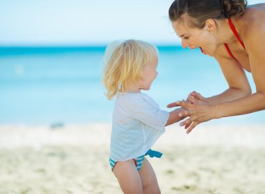 mutlu anne ve bebek kız sahilde oynarken