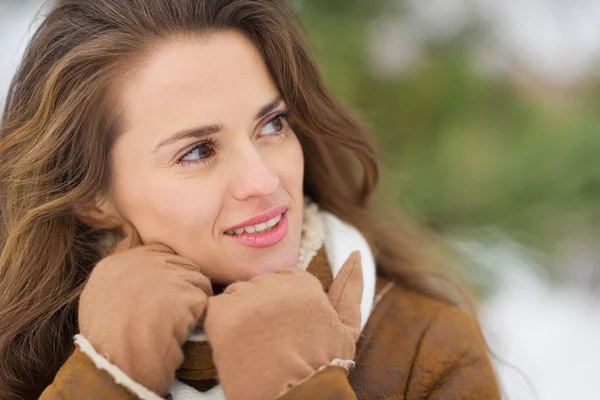 Портрет молодой женщины, смотрящей на копировальное пространство в зимнем парке — стоковое фото